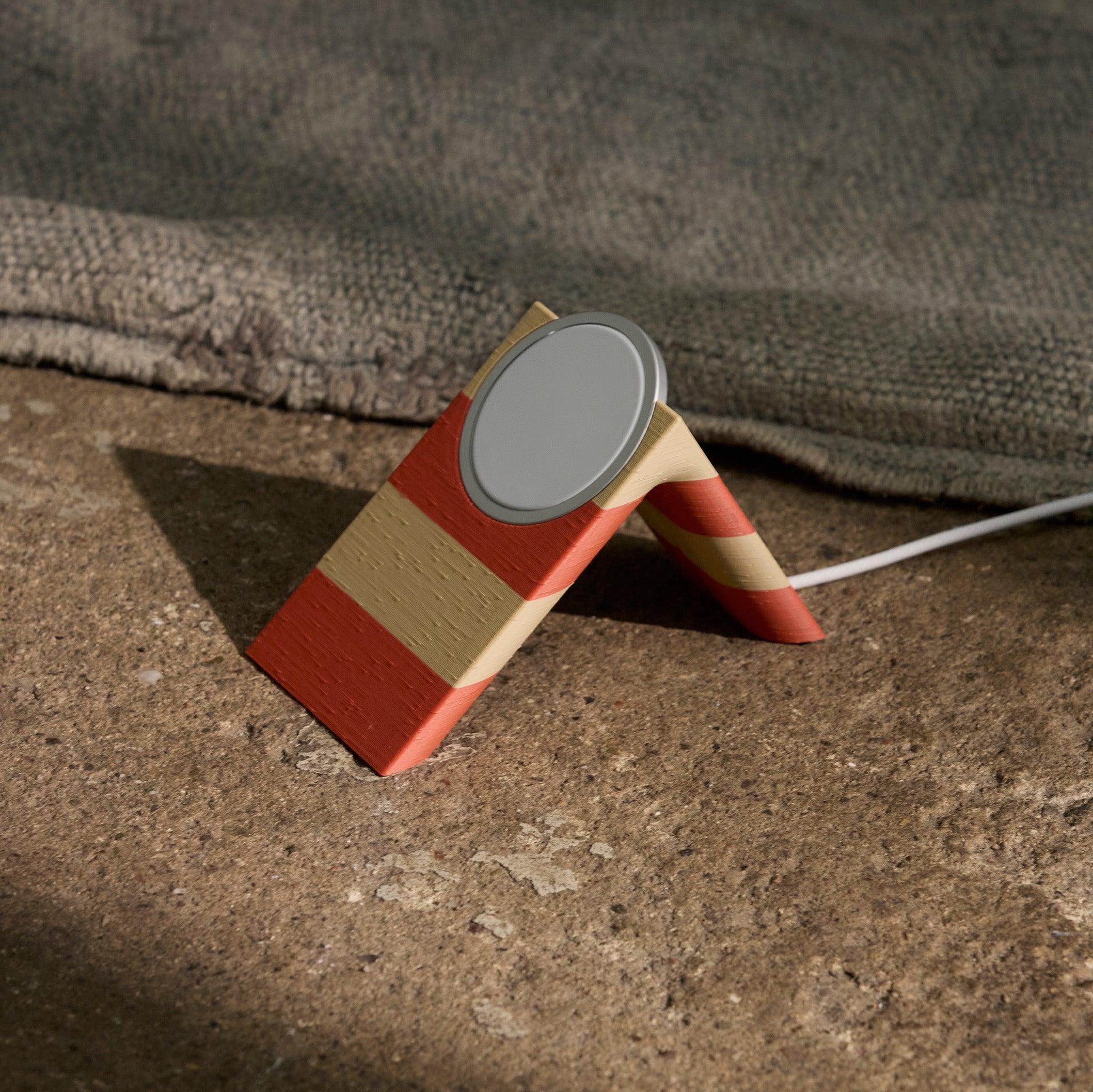 Wireless charging stand with a striped design on a textured surface