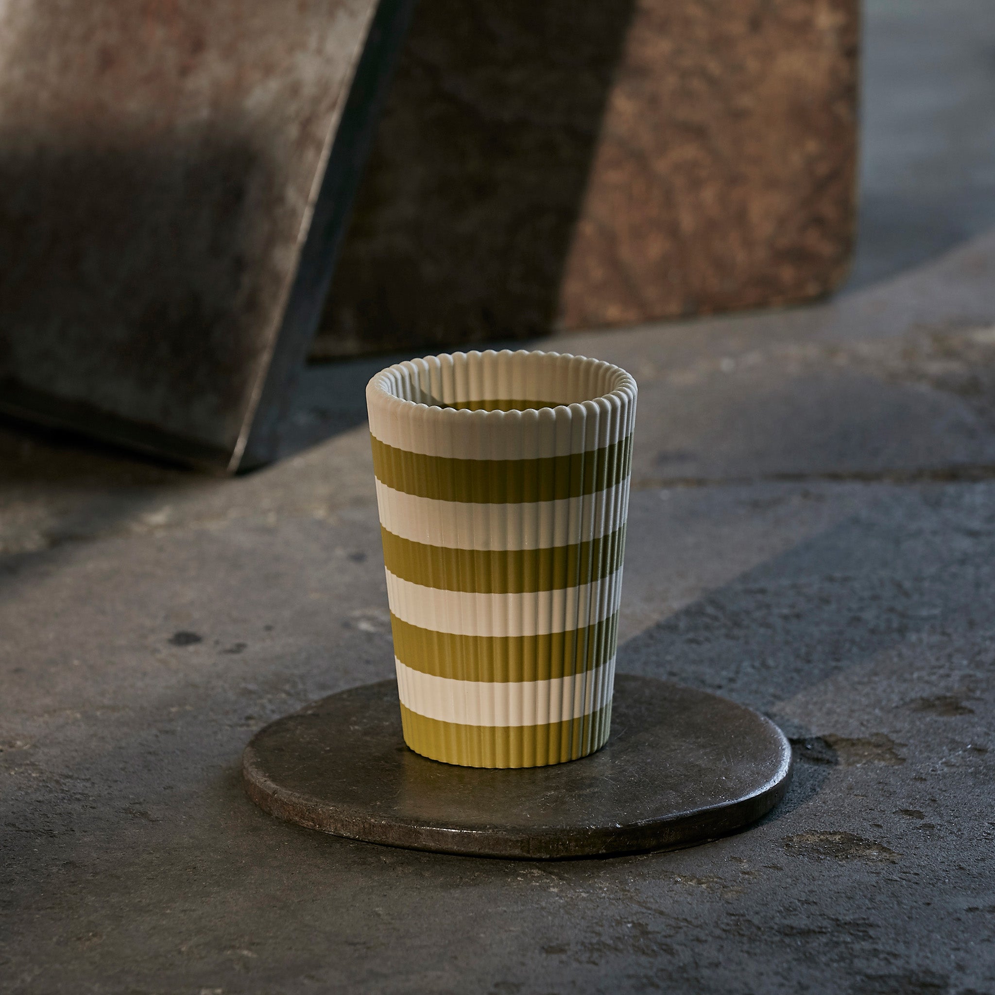 Striped wine cooler on a dark stone surface with a blurred background