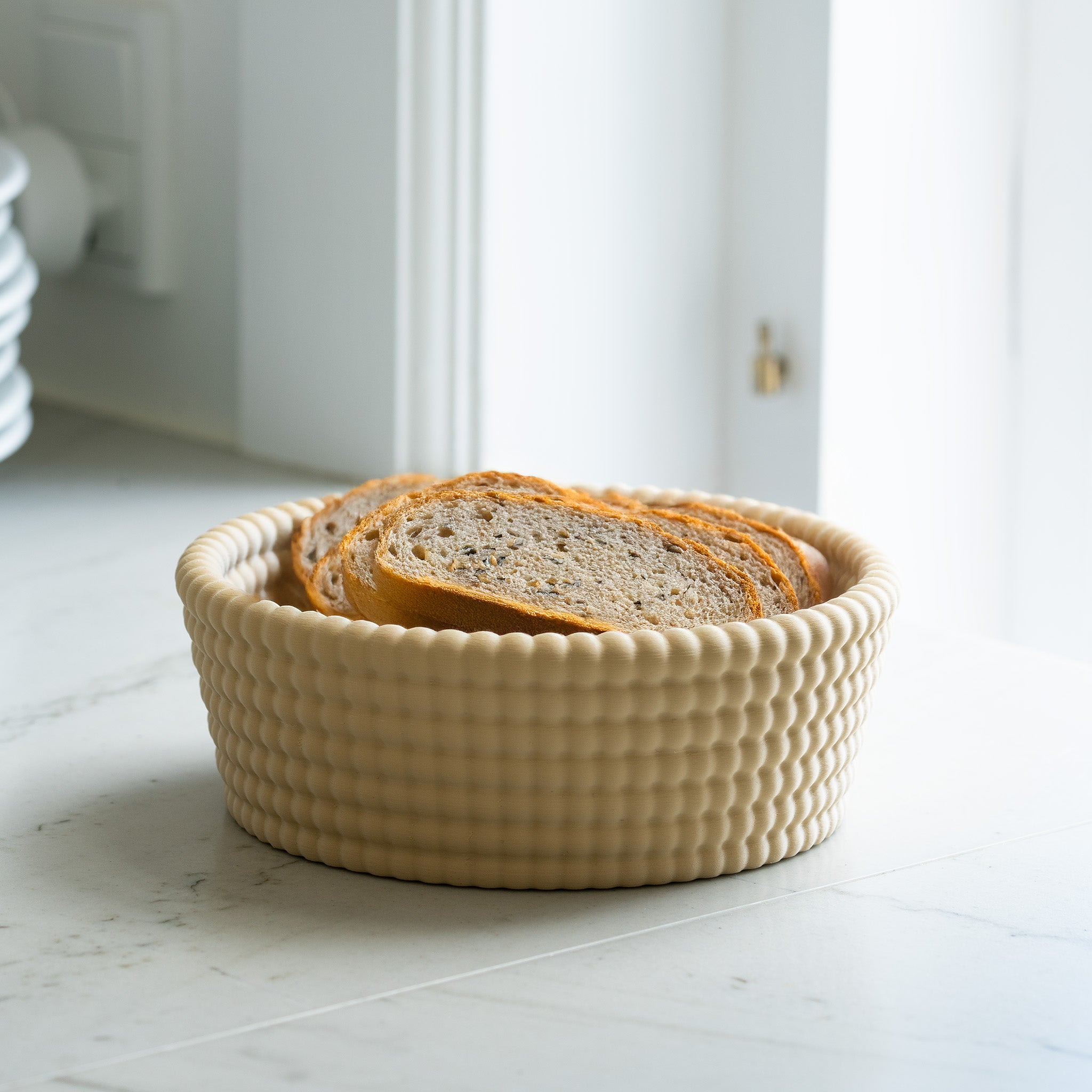 Beige textured bread basket with sliced bread on a light-colored floor.